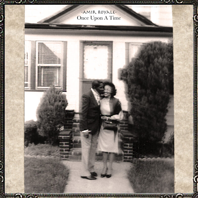 A vintage 1961 photograph of a young man and woman embracing outside of a suburban home.